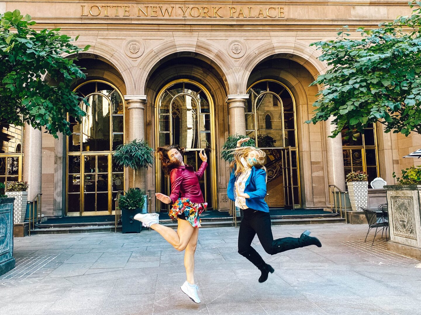 Two girl jumping in front of the Paace Hotel.  They are reminiscent of Blair and Serena in Gossip Girl.
